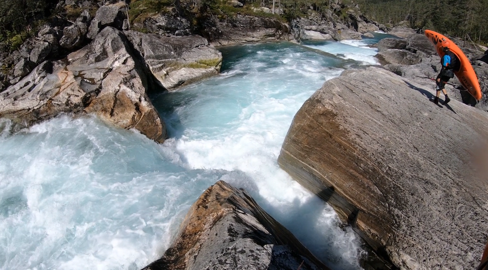 German kayaker Simon Hirt scouting a rapid on a river in Norway.